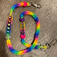 a multicolored lanyard with name and hearts on it, sitting on a wooden surface