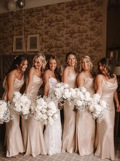 a group of women standing next to each other holding bouquets in front of them