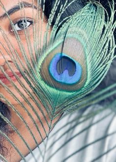 a close up of a person with a peacock feather