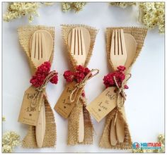 three wooden utensils tied together with burlap and twine, decorated with red flowers