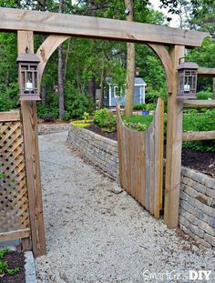 an outdoor garden with a wooden gate and gravel path