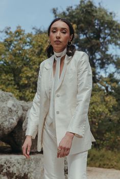 a woman in a white suit is walking