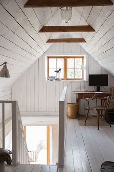 an attic bedroom with white walls and wood flooring is seen from the upstairs level