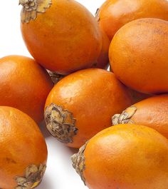 a pile of oranges sitting next to each other on top of a white surface