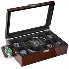 an open wooden watch box with many watches in it's compartments and one on its side