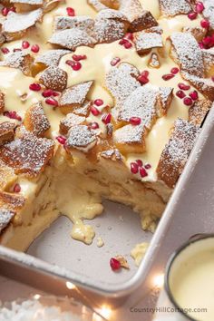 a cake with white frosting and pomegranate on top is in a pan