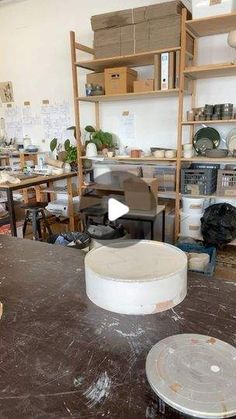 a room filled with lots of clutter and tables covered in white plates on top of wooden shelves