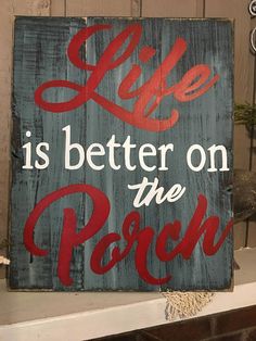 a wooden sign that says life is better on the porch with red lettering in it