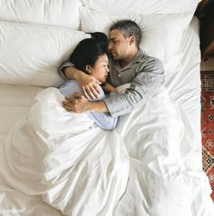 a man and woman laying in bed together