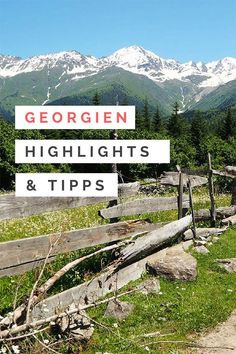 a wooden fence with mountains in the background