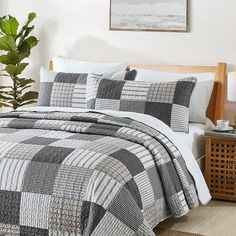 a bed with a black and white checkered comforter set on top of it