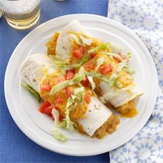 a white plate topped with burritos and veggies