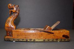 an old wooden box with a carved bird on it's side and a knife sticking out of the lid