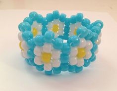 a close up of a bracelet made out of plastic beads and flowers on a white surface