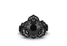 a black diamond ring with white diamonds in the center and an intricate design around it