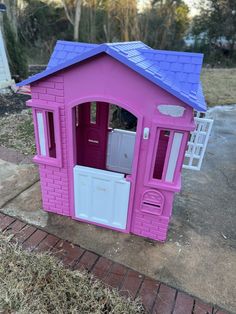 a pink toy house sitting on top of a sidewalk