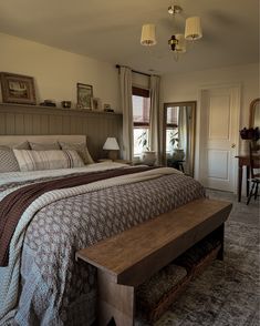 a bedroom with a large bed and wooden bench