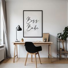 a desk with a chair and a poster on the wall above it that says boss babe