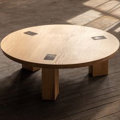 a wooden table sitting on top of a hard wood floor next to a large window