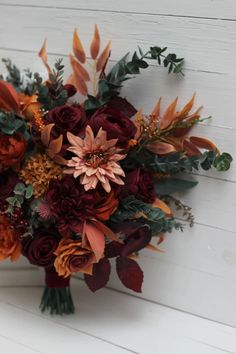 a bouquet of flowers sitting on top of a white wall