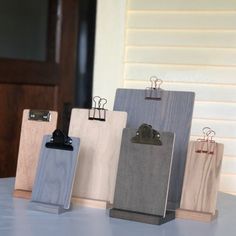 three wooden clipboards with clips attached to them sitting on a table next to a door