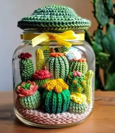 a glass jar filled with crocheted cactus decorations