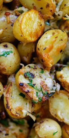 closeup of roasted potatoes with parsley on the top and garlic on the side