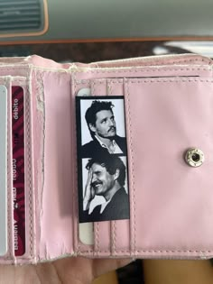 a person holding a pink wallet with two photos on it