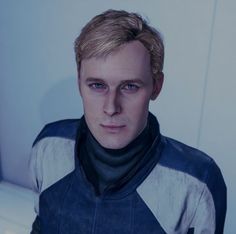 a man with blonde hair and blue eyes wearing a star trek uniform in a white room