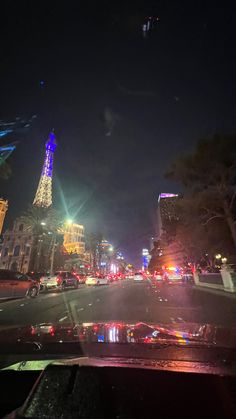 the eiffel tower is lit up at night in paris, france as seen from inside a car