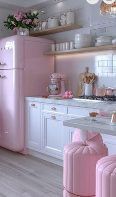 a pink refrigerator in a white kitchen with lots of counter space and decorations on the shelves