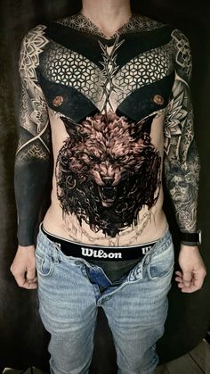 a man with tattoos on his stomach and chest is standing in front of a black background