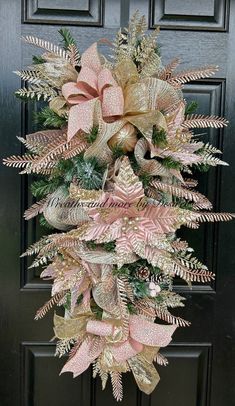 a pink and gold wreath hanging on the front door