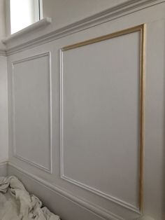 an empty room with white walls and gold trim