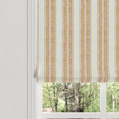 a window with an orange and white striped roman blind