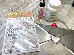 some crafting supplies sitting on top of a wooden floor next to a piece of paper