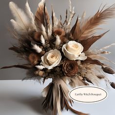 a vase filled with flowers and feathers on top of a table