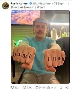 a man sitting in a chair holding two fingers with the word thank written on them