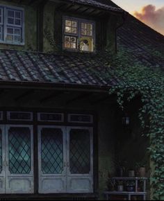 an old house with ivy growing on the roof and windows, in front of a cloudy sky