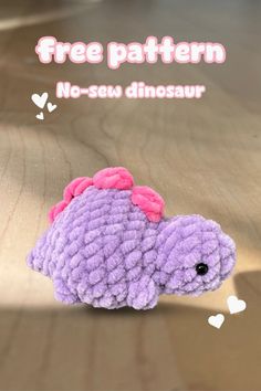 a purple crocheted stuffed animal laying on top of a wooden floor with the caption free pattern no sew dinosaur