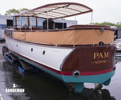 a boat that is sitting in the water next to a dock and some other boats