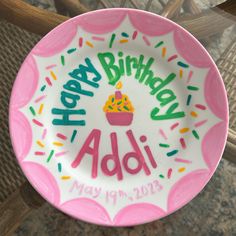 a pink and white birthday plate with sprinkles on it that says happy birthday adi