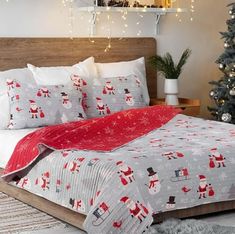 a bed covered in christmas themed sheets and pillows