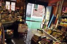 a room filled with lots of books next to a doorway that leads into a building