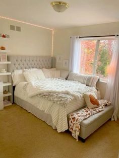 a bedroom with a large bed and white furniture