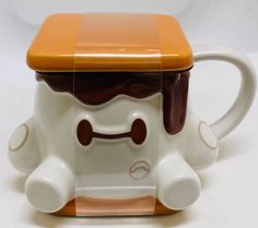 a coffee mug with a brown and white design on the front, inside it is shaped like a bear