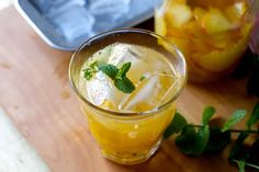 a glass filled with lemonade and mint sitting on top of a cutting board