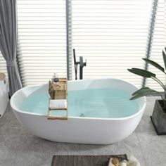 a bathroom with a large bathtub, rugs and plants in the corner on the floor