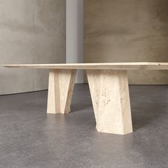 a marble bench sitting on top of a cement floor next to a concrete wall in an empty room