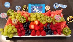 a platter filled with fruit and topped with stickers